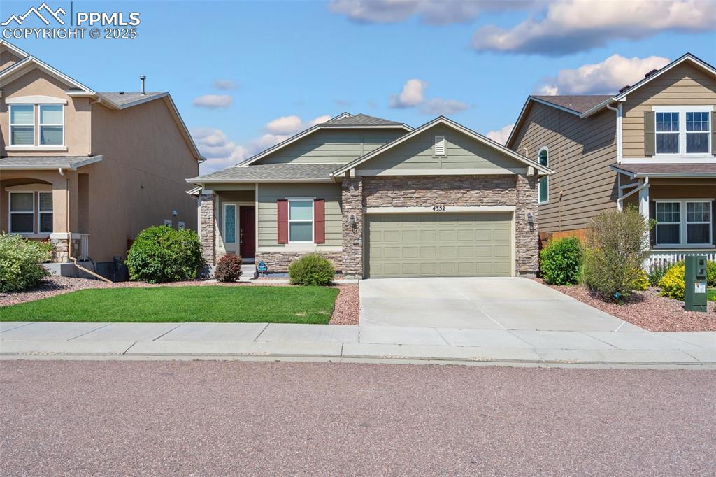 Image 42 of 45: Craftsman-style home with stone siding, concrete driveway, an attached gara