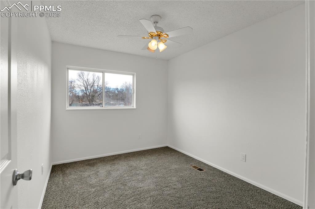 Image 16 of 28: Bedroom 2 on upper level featuring carpet flooring, a textured ceiling, and