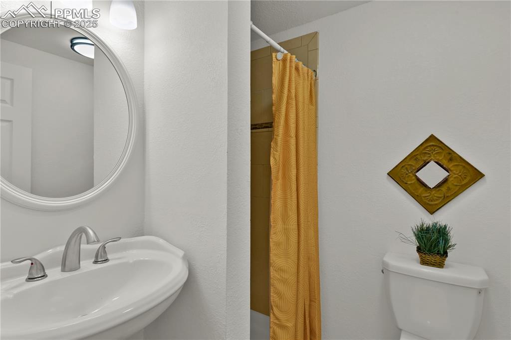 Image 24 of 28: 3/4 Bathroom on the lower level featuring a shower with shower curtain