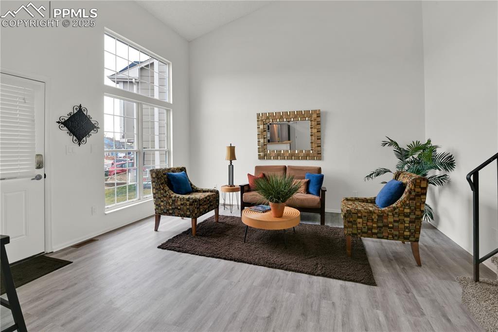 Image 4 of 28: Another view of the Living area featuring high vaulted ceiling and light wo