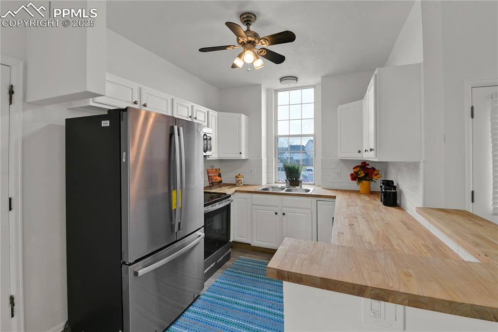 Image 7 of 28: Kitchen featuring appliances with stainless steel finishes, wooden counters
