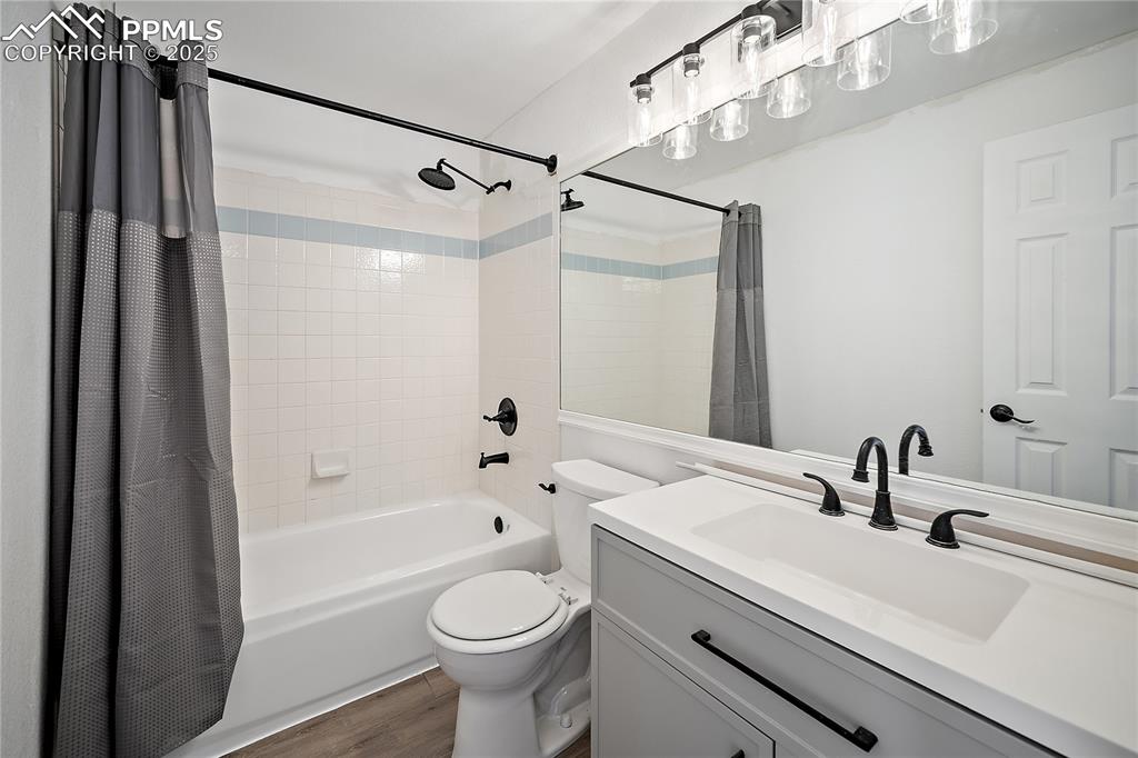 Image 24 of 42: Upstairs full bath with new vanity, lighting and flooring.