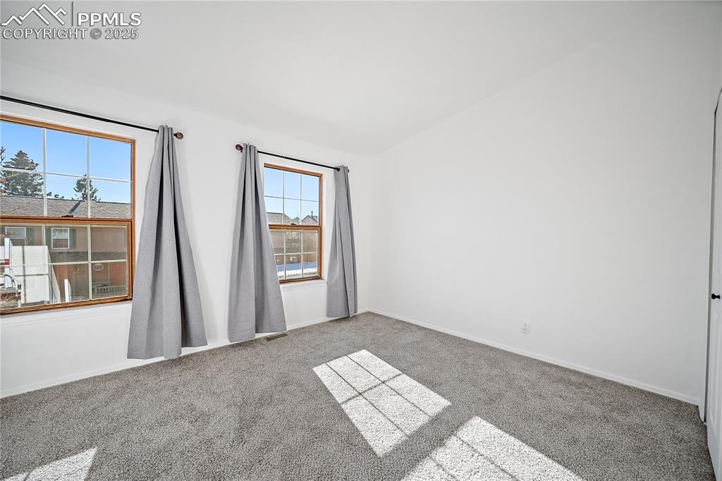 Image 25 of 42: Upstairs bedroom 2 with vaulted ceilings. 
