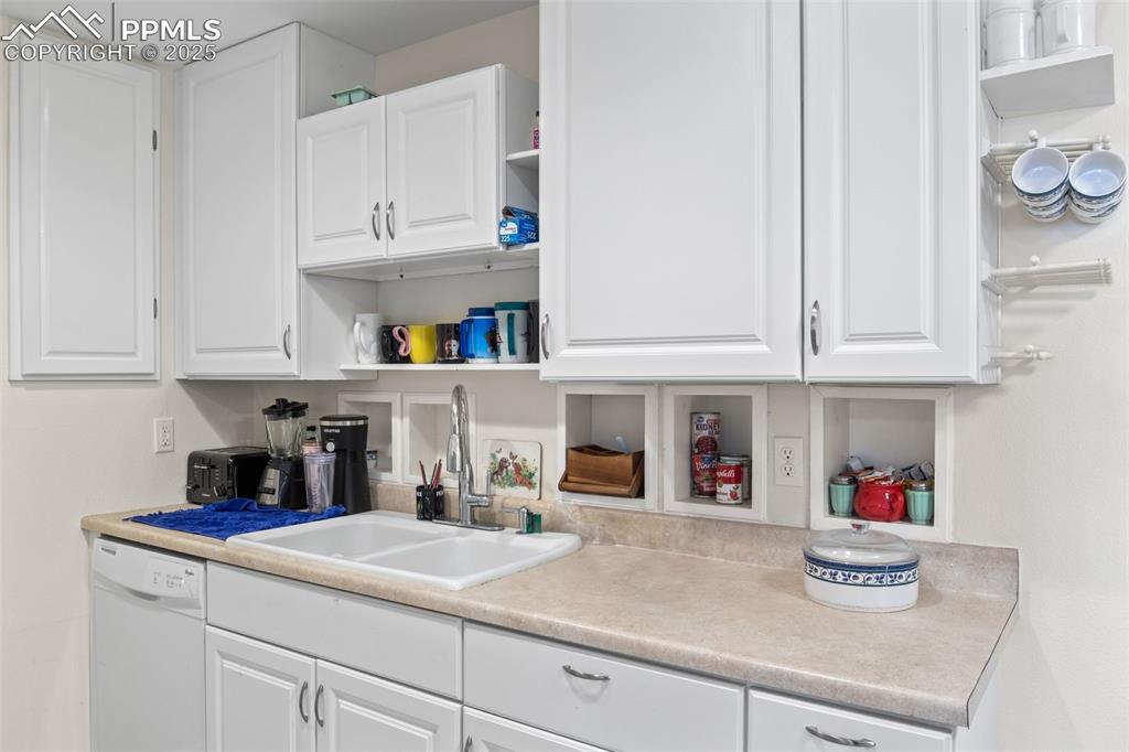 Image 11 of 21: Kitchen with open shelves, white cabinets, and white dishwasher