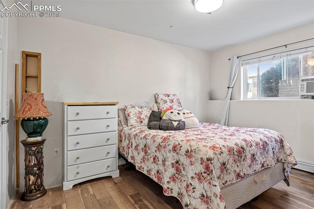 Image 14 of 21: Bedroom with hardwood / wood-style floors
