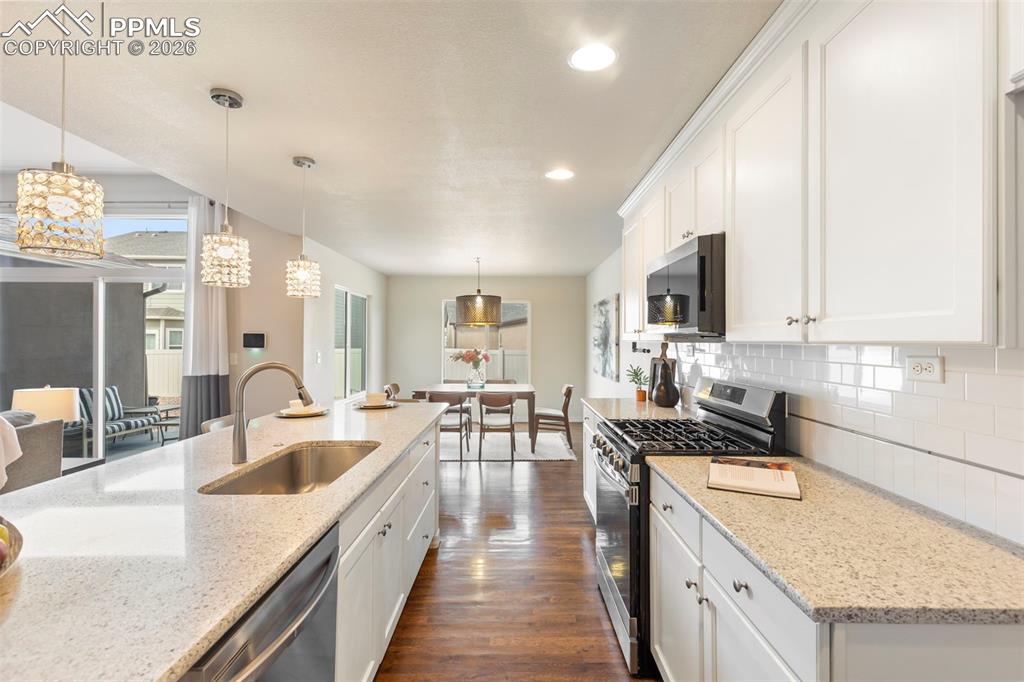 Image 10 of 44: Open kitchen and dining layout showcasing island seating and connection to 