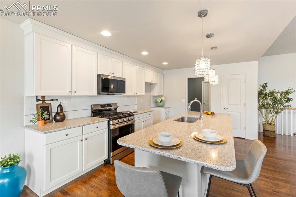 Image 13 of 44: Dining space connected to the kitchen, showcasing hardwood floors and open 