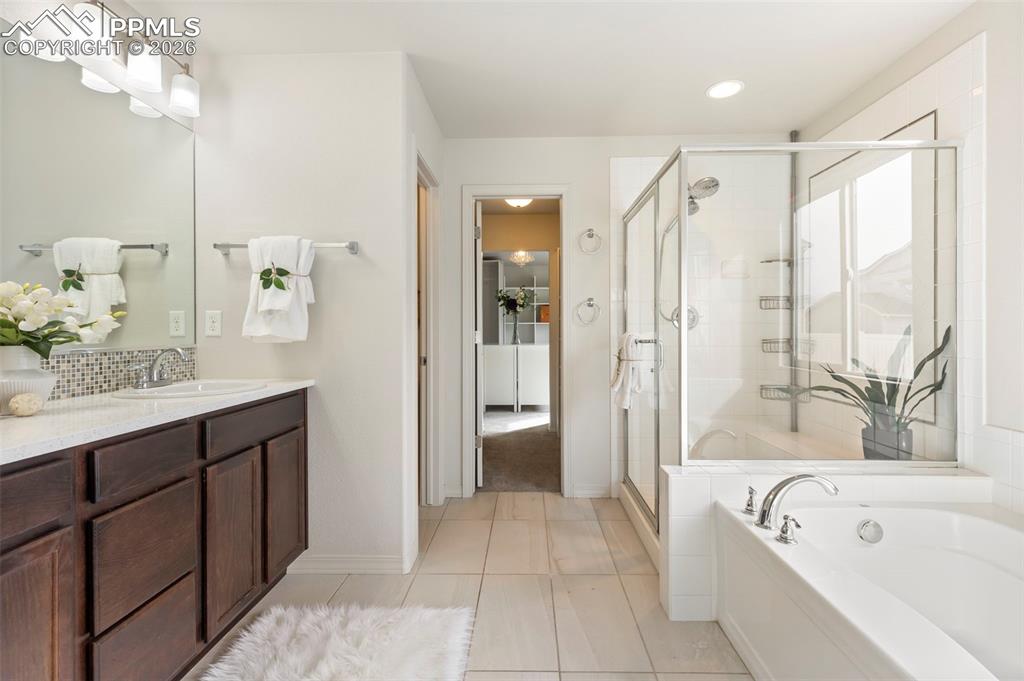 Image 21 of 44: Custom double walk-in closet featuring built-in drawers, shelving, and hang