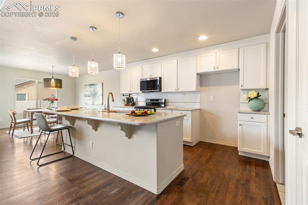 Image 9 of 44: Spacious kitchen with center island, pantry storage, and open sightlines to