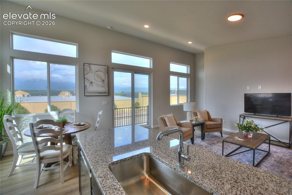 Image 10 of 25: Open-concept living area with vaulted ceilings, recessed lighting, and larg