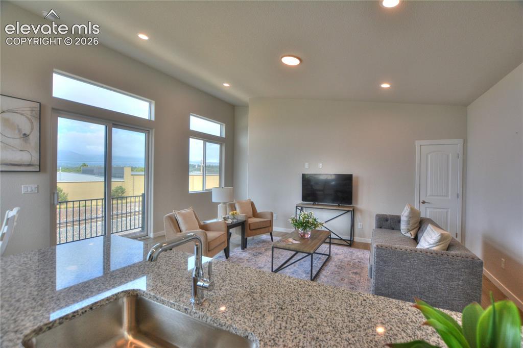 Image 11 of 25: Open-concept living area featuring expansive windows with glass doors overl