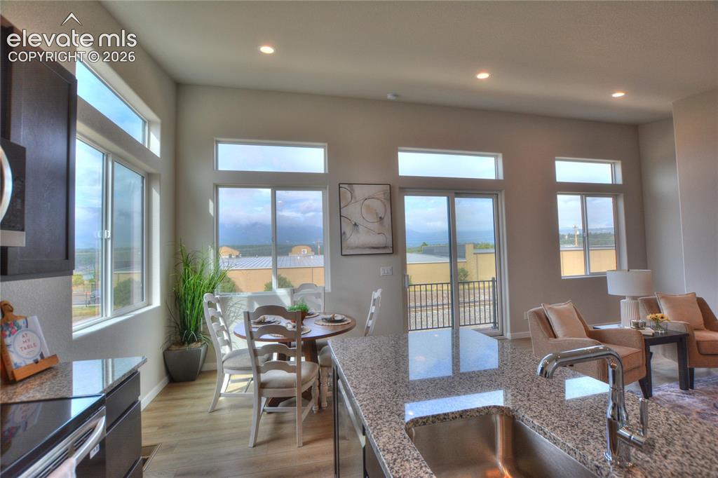 Image 12 of 25: Open-concept living space featuring floor-to-finish wood flooring, granite