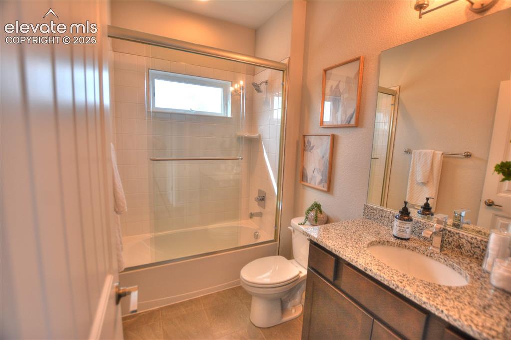 Image 14 of 25: Contemporary bathroom featuring a granite-topped vanity with dual sink basi