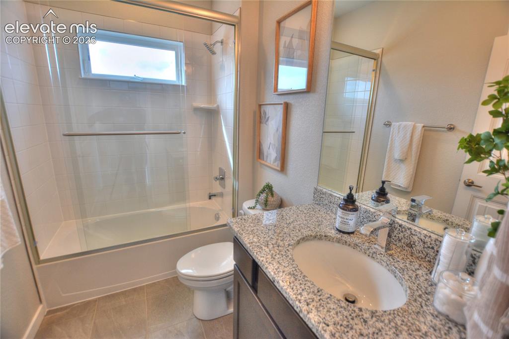 Image 15 of 25: Contemporary bathroom featuring a granite-topped vanity with an undermount 