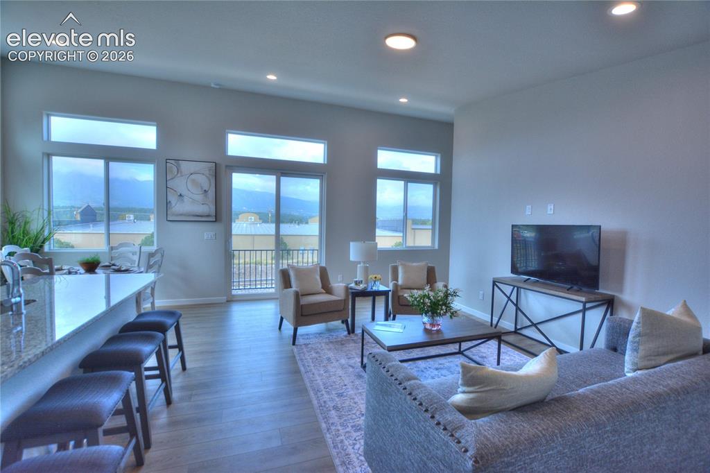 Image 16 of 25: Open-concept living area featuring hardwood flooring, recessed ceiling ligh