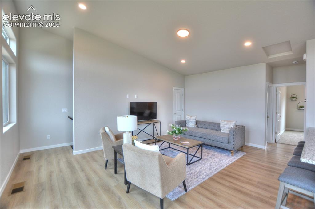 Image 6 of 25: Bright, open-concept living area featuring recessed ceiling lighting, wood-