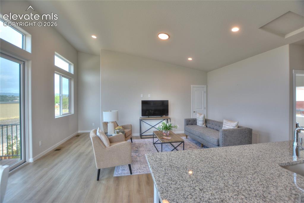 Image 9 of 25: Open-concept living area showcasing wood-finish flooring throughout, recess