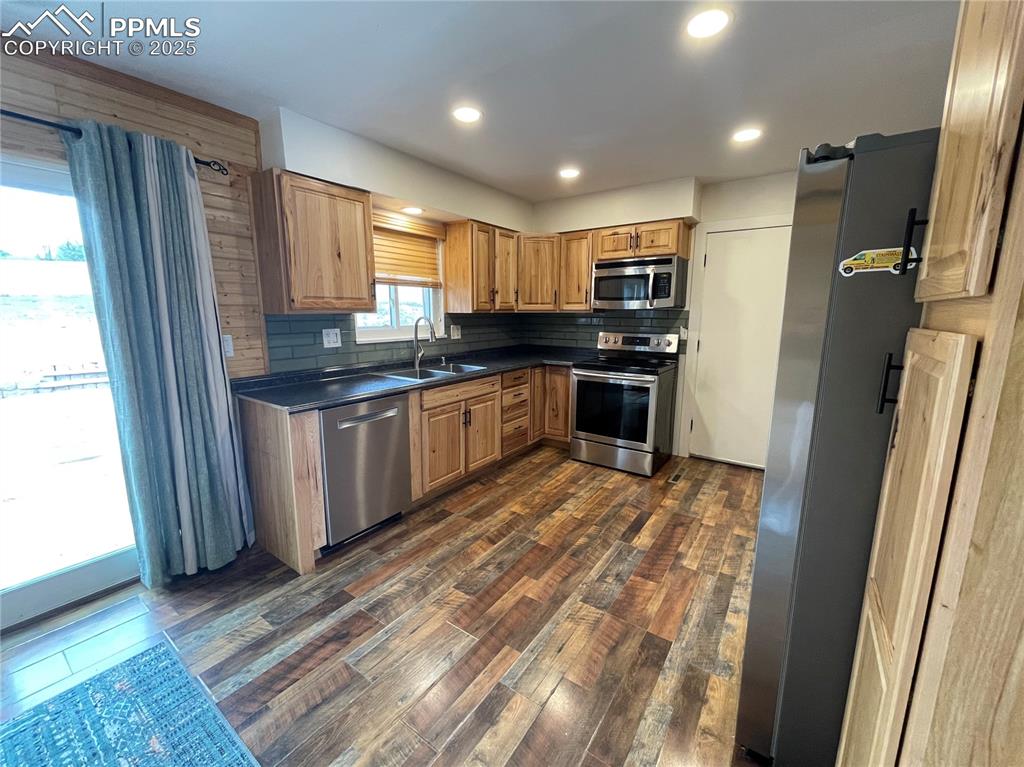 Image 12 of 39: Kitchen featuring appliances with stainless steel finishes, tasteful backsp