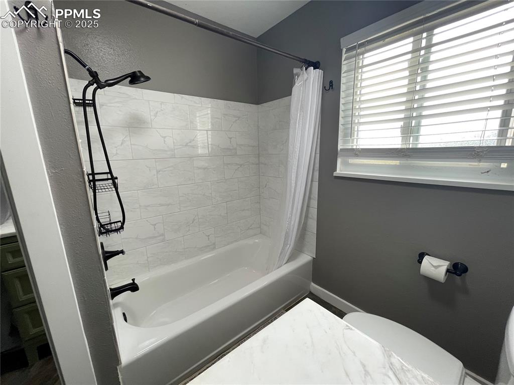 Image 22 of 39: Bathroom featuring shower / bath combo and toilet