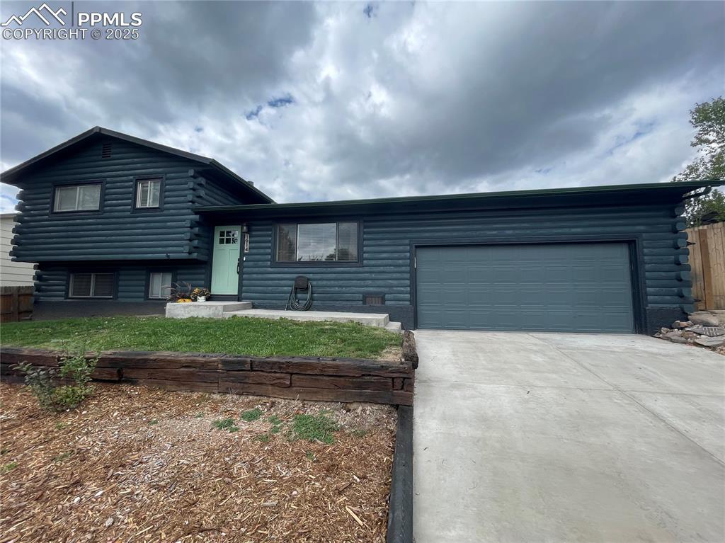 Image 3 of 39: Cabin featuring log siding, concrete driveway, and a garage