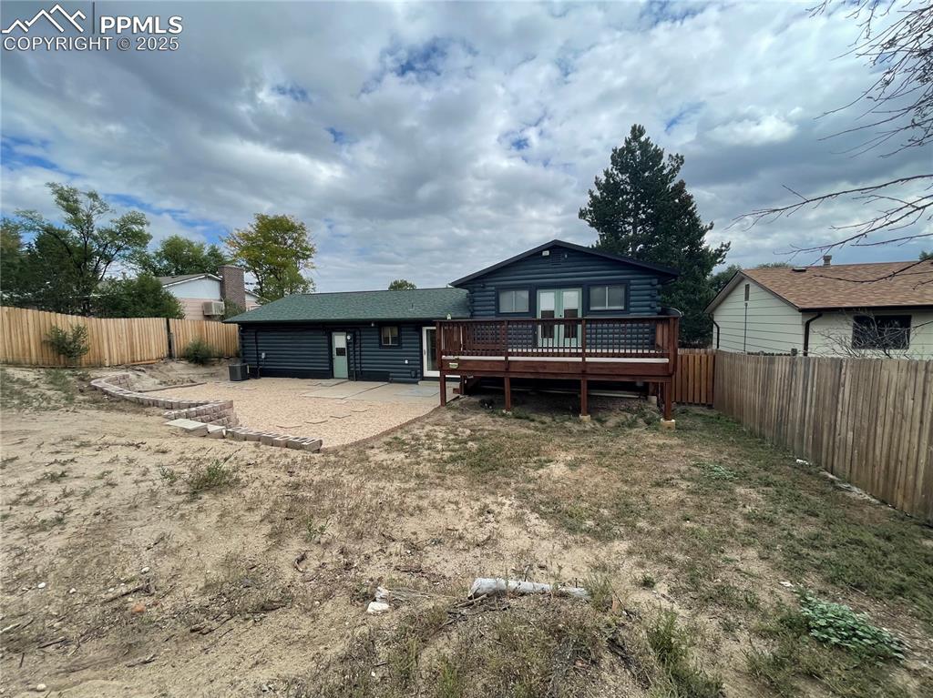 Image 37 of 39: Rear view of house with a fenced backyard and a wooden deck