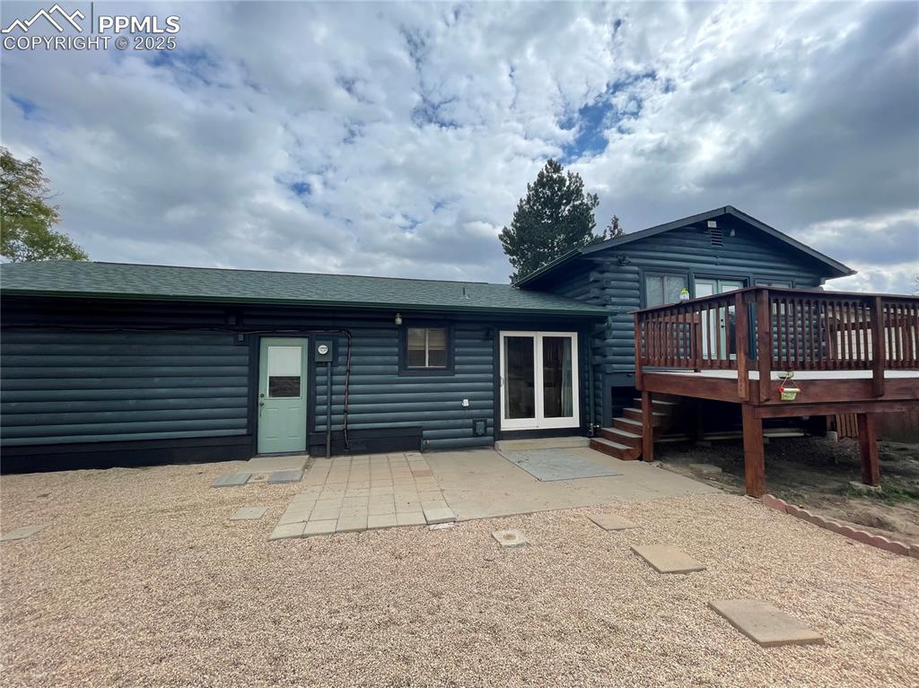 Image 38 of 39: Back of house with a patio, roof with shingles, and a wooden deck