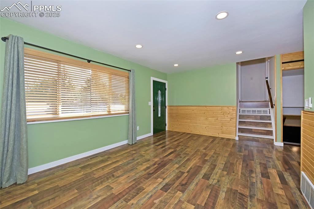 Image 7 of 39: Spare room with wood finished floors, recessed lighting, and stairs