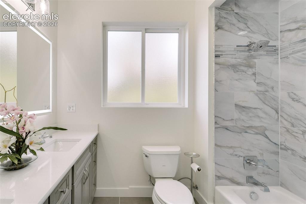 Image 12 of 49: Main Level Full Bathroom with dual sink vanity, quartz countertop, illumina
