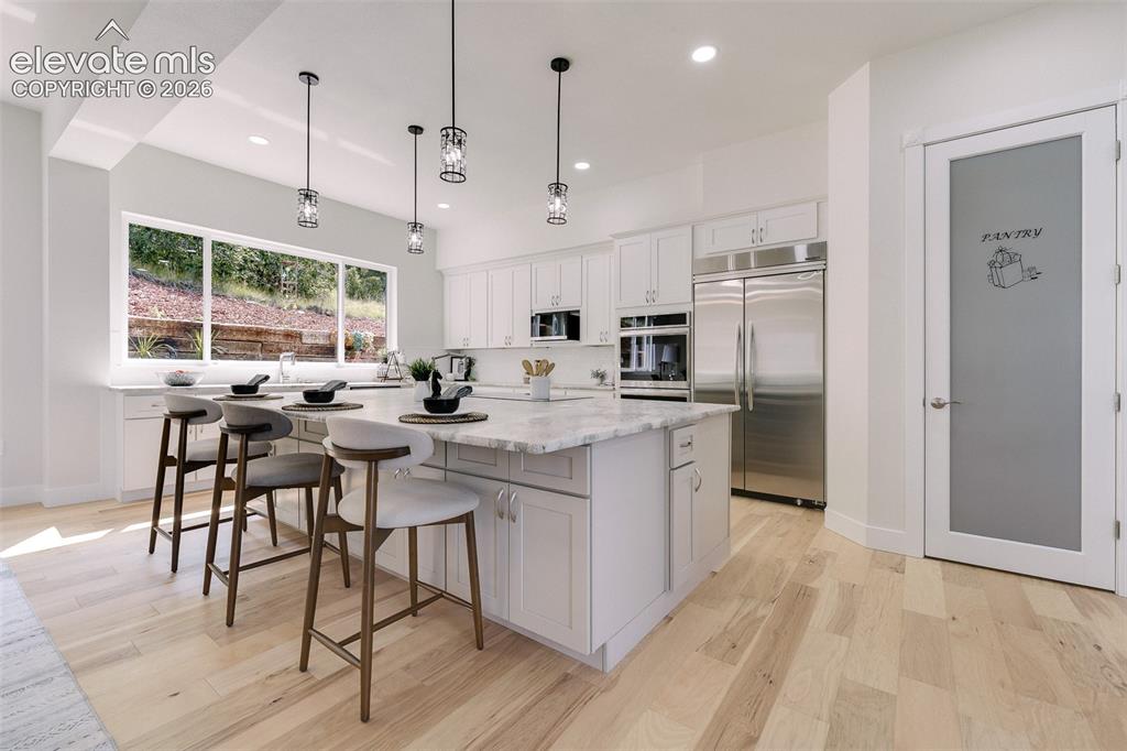 Image 13 of 49: The gourmet kitchen, features natural wood cabinetry, stone countertops, a