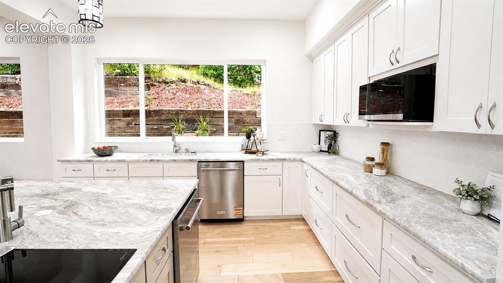 Image 15 of 49: Beautiful leathered granite countertops in the Kitchen, 2 dishwashers, and
