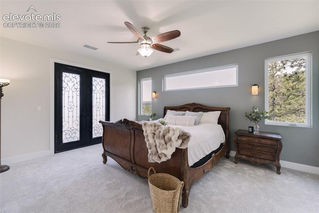 Image 29 of 49: Upper Level Primary Retreat with neutral carpet, a lighted ceiling fan, and