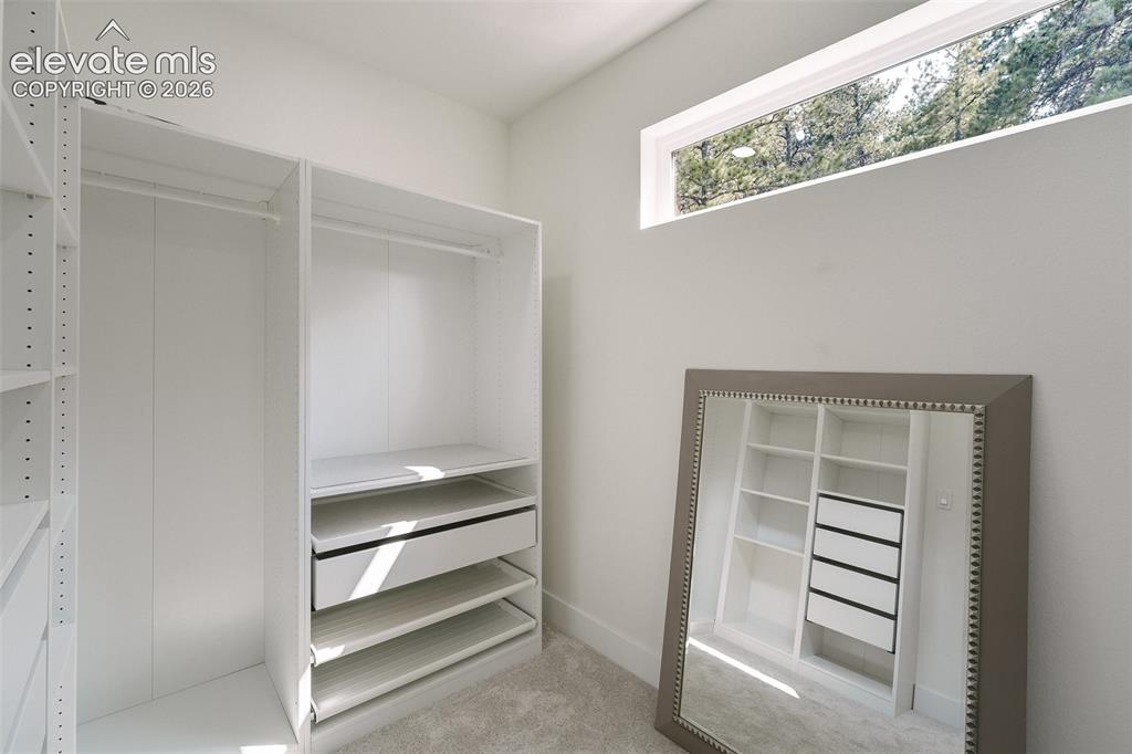 Image 32 of 49: Spacious walk in closet with organizer in the upper level Primary Suite.