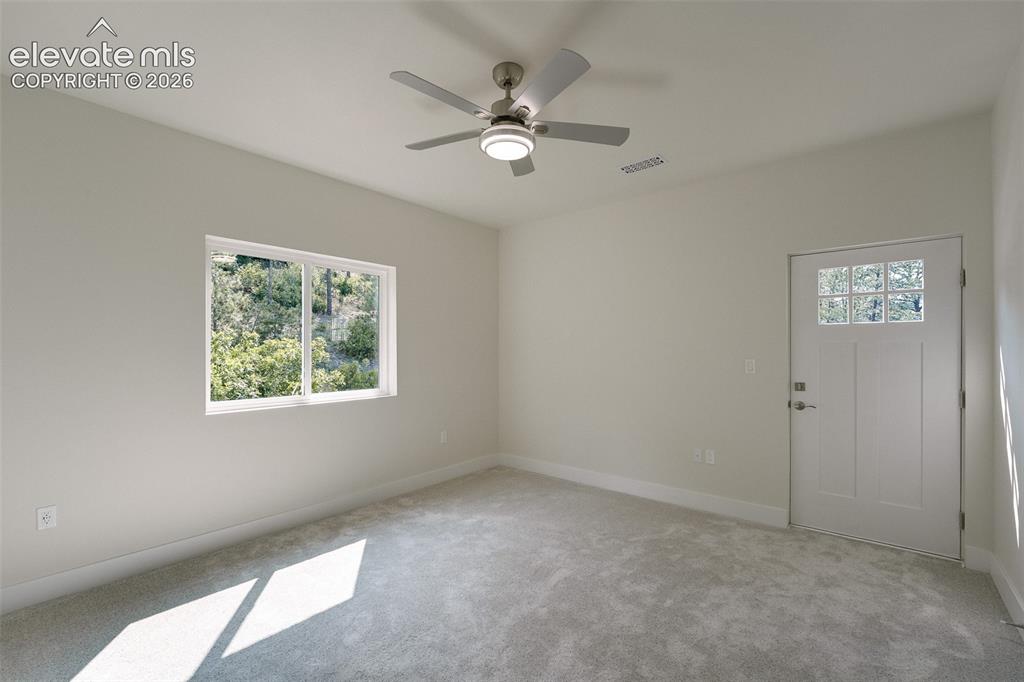 Image 35 of 49: Upper Level Bedroom #4 with neutral carpet, a lighted ceiling fan, and wal