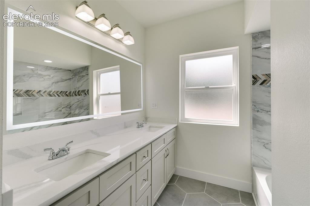 Image 37 of 49: Upper Level Full Bathroom with dual sink vanity, quartz countertop, illumin