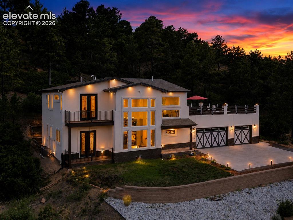 Image 4 of 49: Sunset view of home with magnificent mountain, forest, & city-light views.