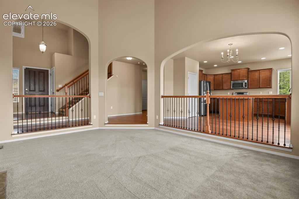 Image 10 of 50: Arched doorways, open-concept design, wood-finish flooring, staircase with 
