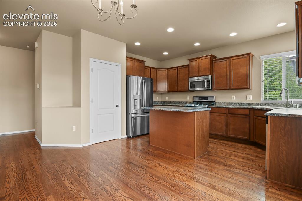 Image 16 of 50: Kitchen featuring wood-finish flooring, recessed lighting, wood cabinetry,