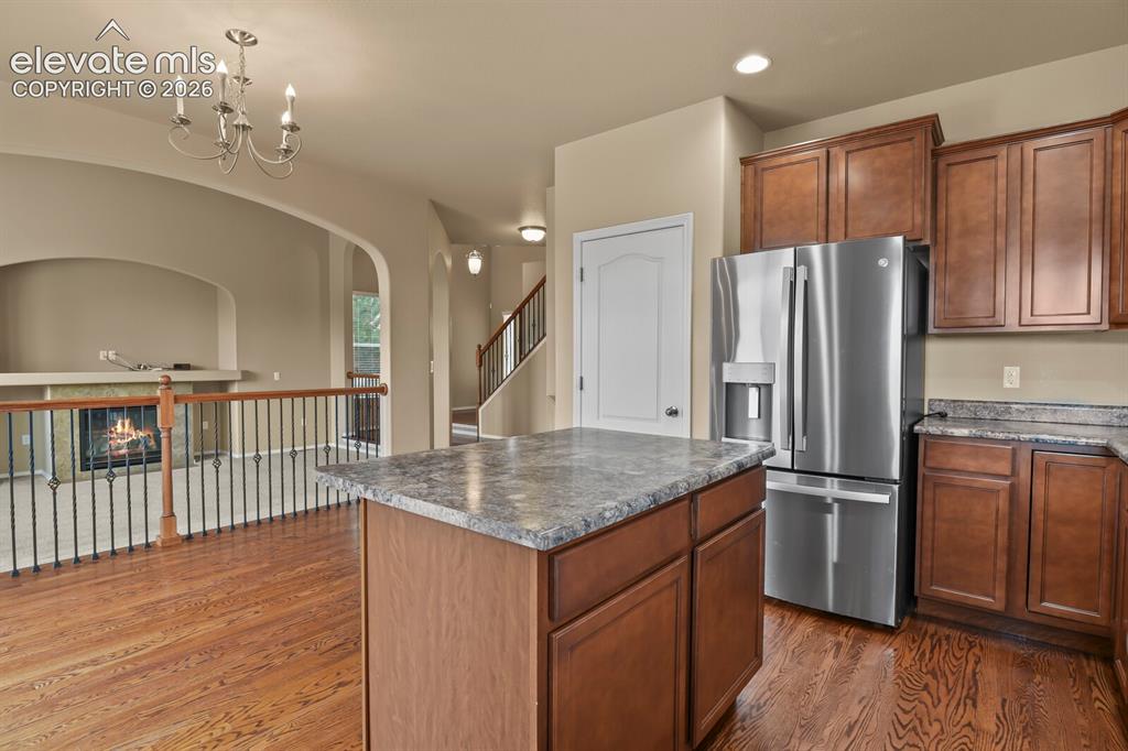 Image 18 of 50: Kitchen featuring wood cabinetry, stainless steel refrigerator, and a centr