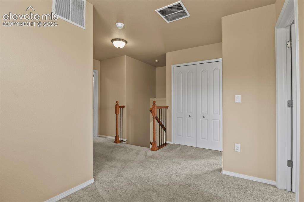 Image 22 of 50: Neutral-toned carpet flooring, light beige wall paint, white bi-fold closet