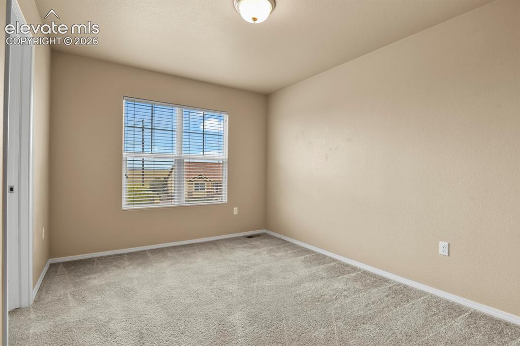 Image 29 of 50: Neutral tone wall paint, light gray carpeting, ceiling-mounted light fixtur