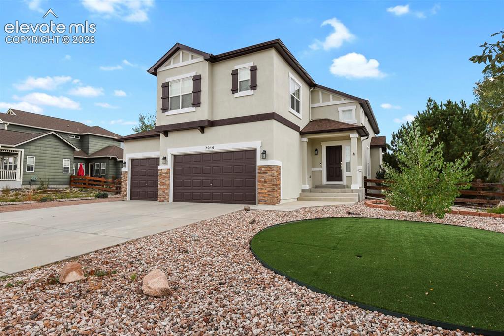 Image 3 of 50: Two-story stucco exterior with stone accents, attached two-car garage, conc