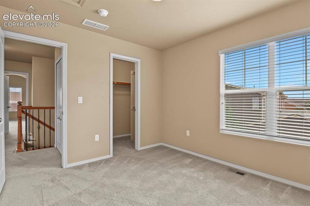 Image 33 of 50: Carpeted flooring, neutral wall tones, window with horizontal blinds, open 