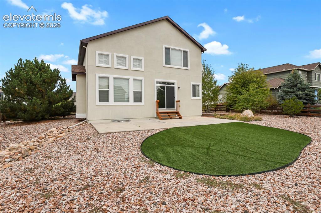 Image 46 of 50: Rear exterior with stucco finish and a concrete patio