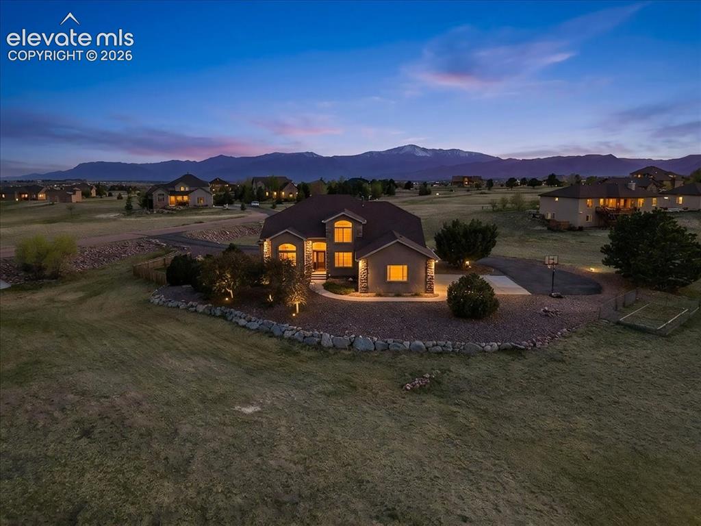 Image 1 of 47: Stucco exterior with stone accents, illuminated landscaping, a paved drivew