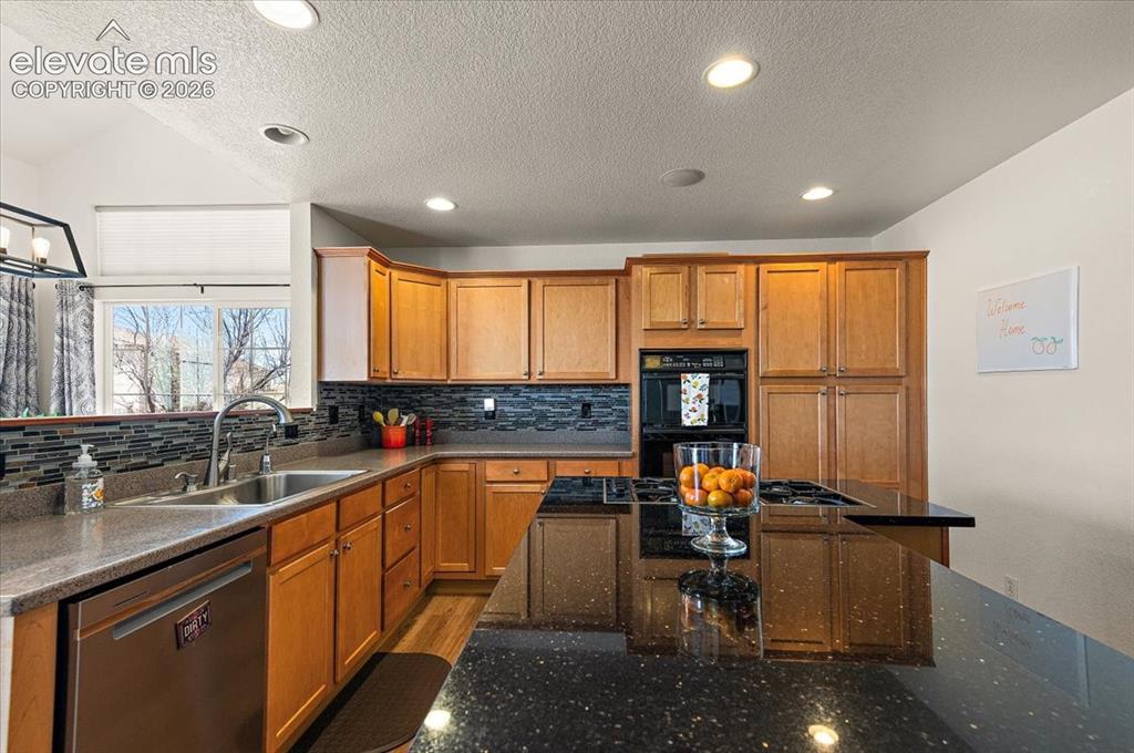 Image 10 of 47: Kitchen featuring wood cabinetry, stainless steel dishwasher, double basin