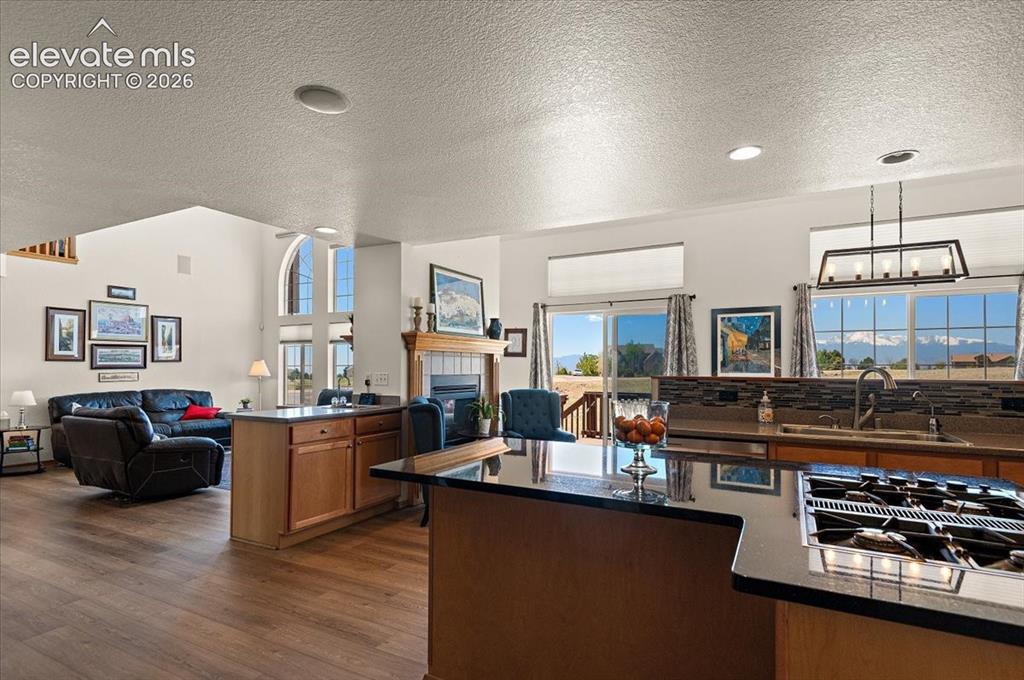 Image 11 of 47: Kitchen featuring dark countertops, a built-in gas range, and a tile backsp
