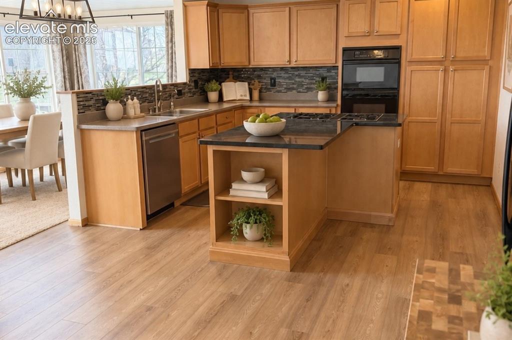 Image 12 of 48: Kitchen featuring wood-finish flooring, light wood cabinetry, a built-in ov