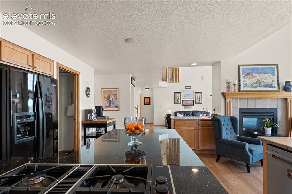Image 13 of 47: Kitchen featuring black speckled countertops, a built-in gas cooktop, and l