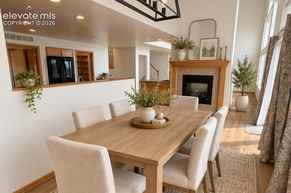 Image 13 of 48: Dining area featuring a fireplace with a wood mantle and tile surround, rec