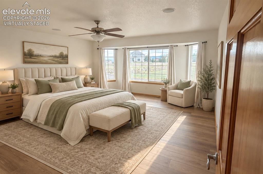 Image 17 of 48: Expansive main-level primary room featuring wood-finish flooring, a ceiling
